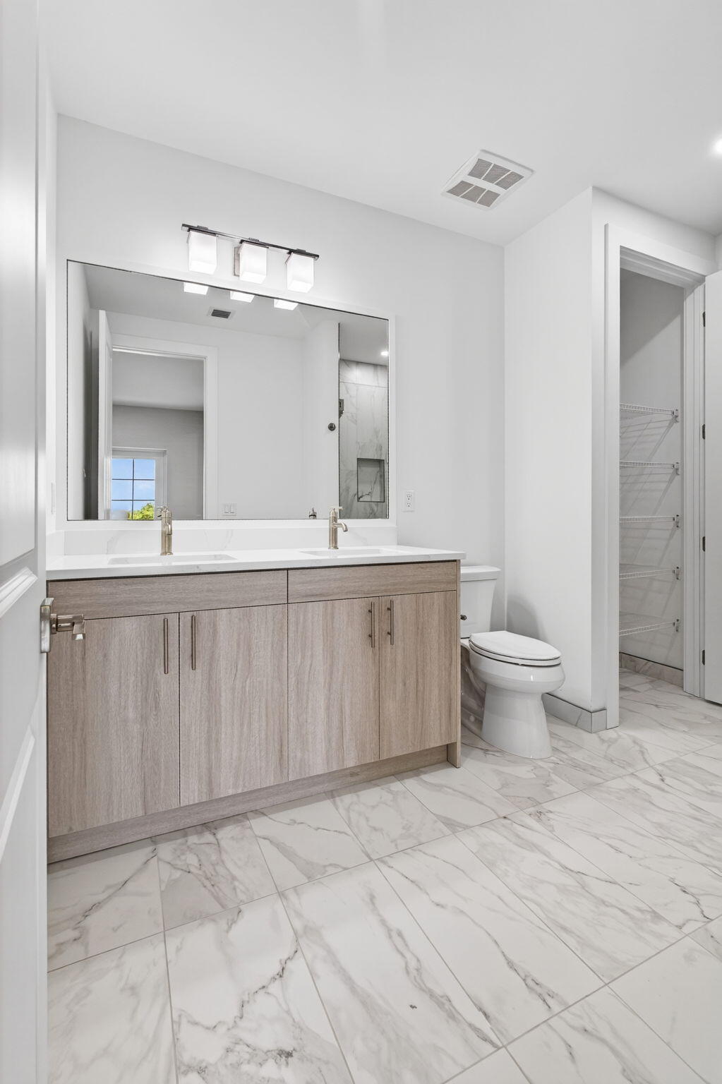 135 Water Pointe Place, Unit 22 Jupiter, FL 33477 - Photo 25 of 55 a bathroom with a sink a toilet a mirror and vanity