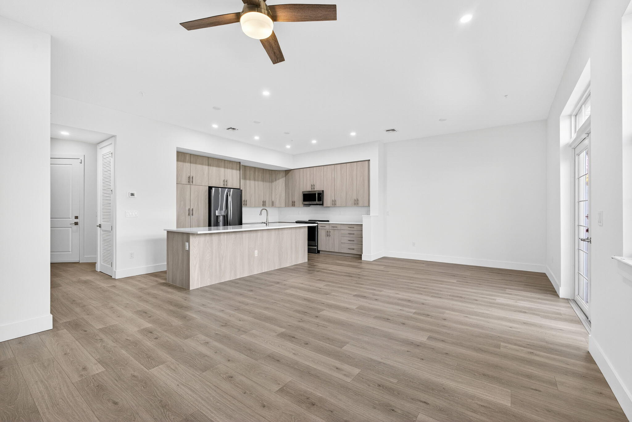 135 Water Pointe Place, Unit 22 Jupiter, FL 33477 - Photo 49 of 55 a view of kitchen and empty room with wooden floor