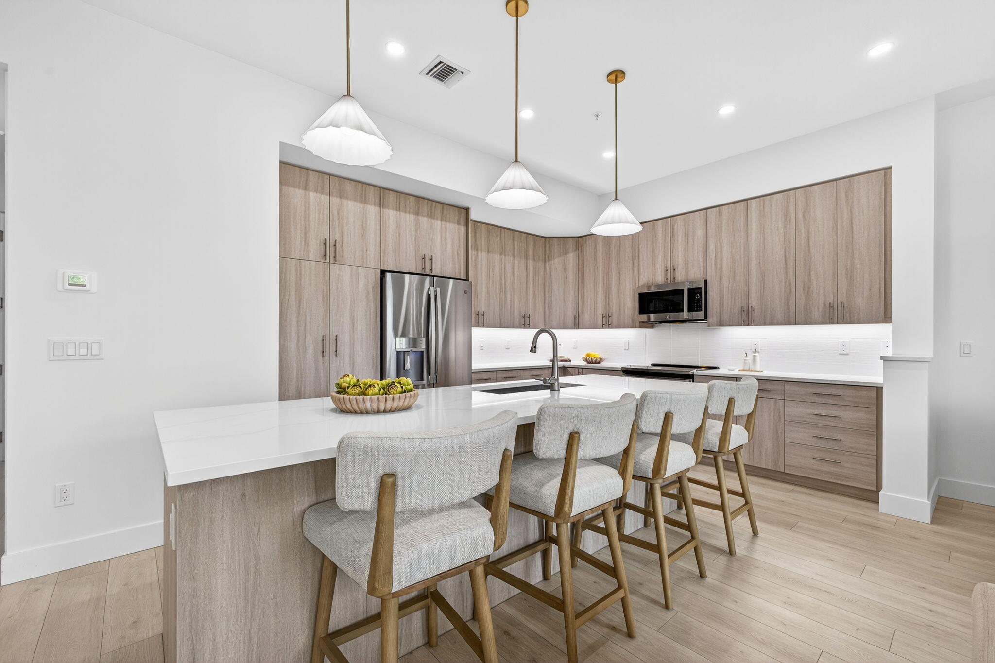 135 Water Pointe Place, Unit 22 Jupiter, FL 33477 - Photo 5 of 55 a kitchen with stainless steel appliances kitchen island granite countertop a dining table chairs and white cabinets
