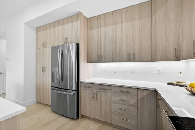 a kitchen with stainless steel appliances kitchen island granite countertop a sink a stove and a refrigerator