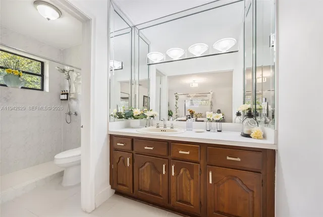a bathroom with a sink a toilet and shower