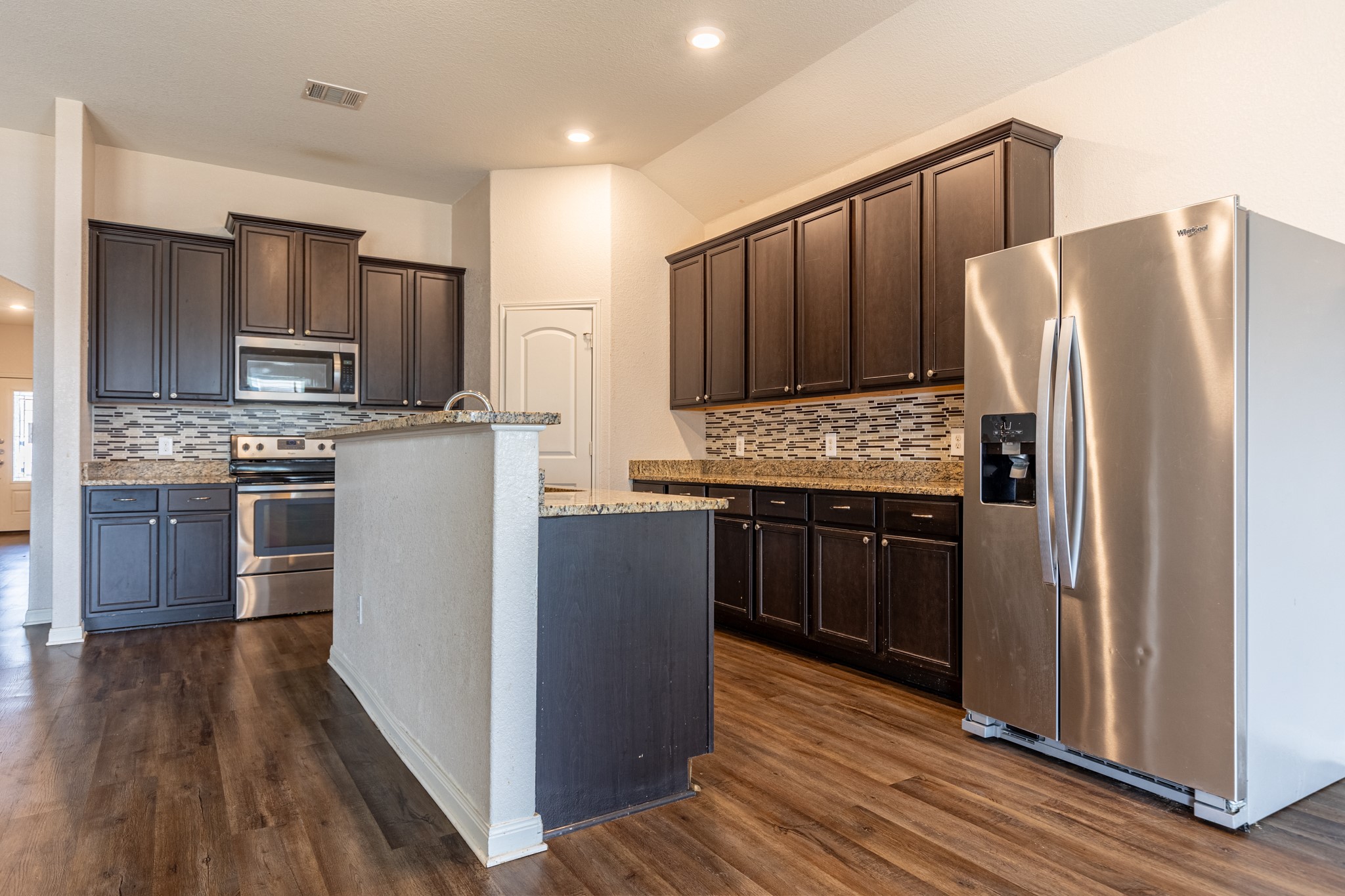 20017 Hubert R Humphrey Road Manor, TX 78653 - Photo 15 of 35 A well-appointed kitchen showcasing rich cabinetry, granite countertops, and modern stainless steel appliances.