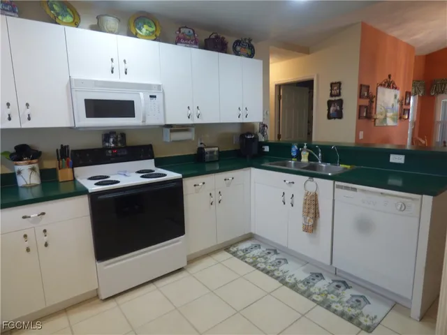 a kitchen with granite countertop white cabinets and white appliances