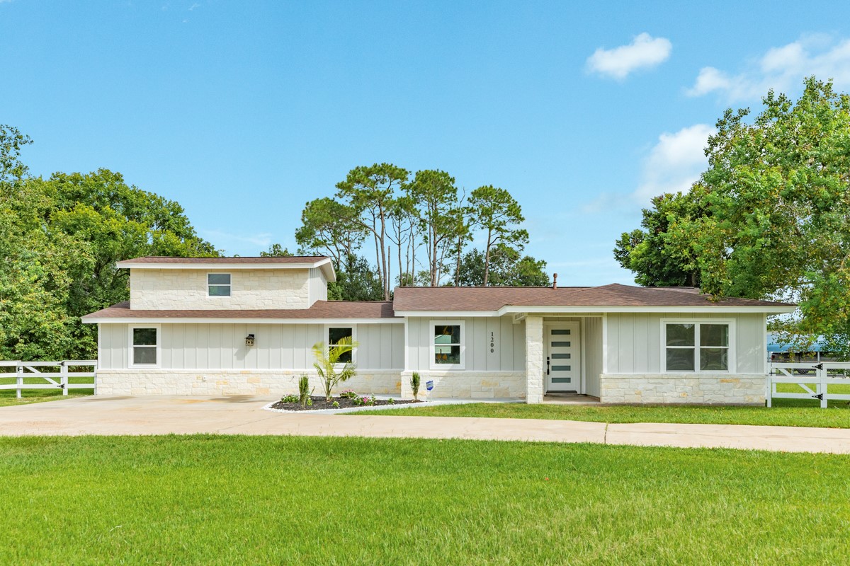 a front view of a house with a garden and yard