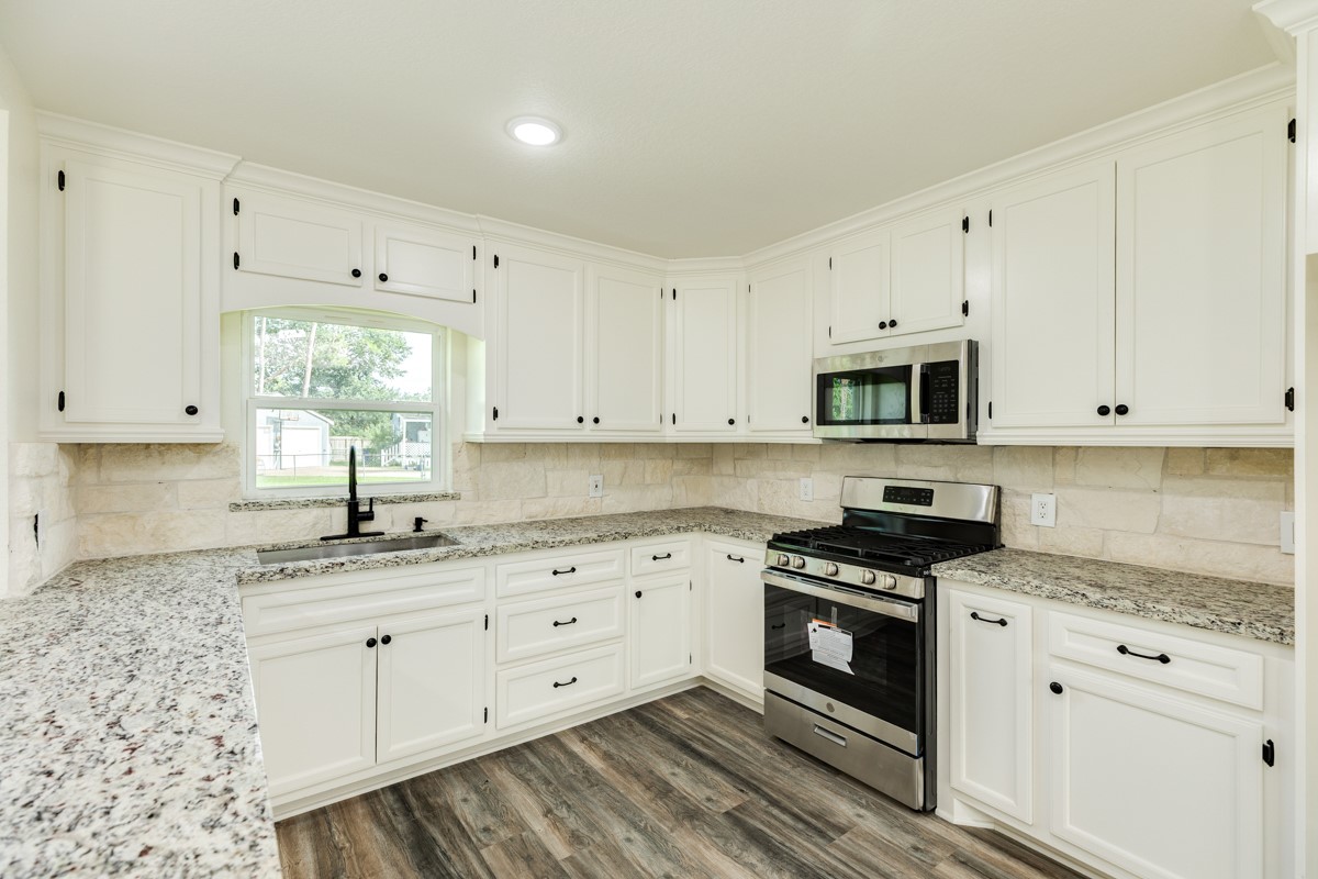 1200 Gifford Lane Angleton, TX 77515 - Photo 14 of 26 a kitchen with granite countertop white cabinets white stainless steel appliances and sink