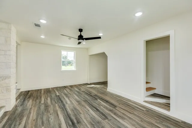 a view of empty room with wooden floor