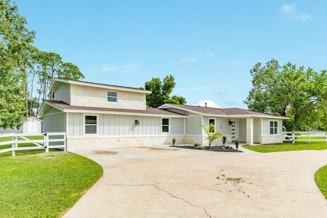 a front view of a house with a yard and trees