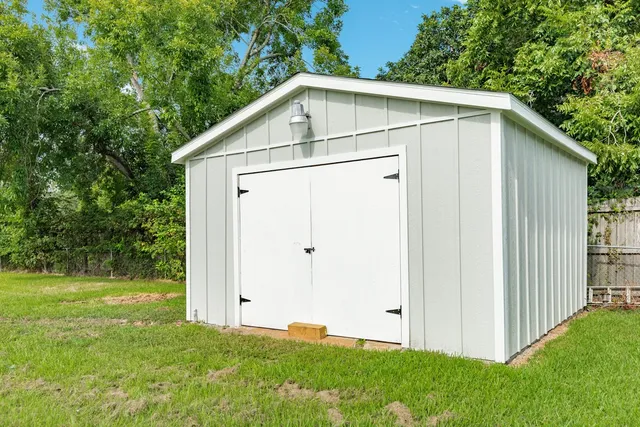 a white house with green field in front of it