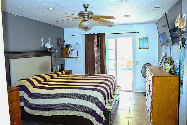 a bedroom with a bed dresser and a flat screen tv