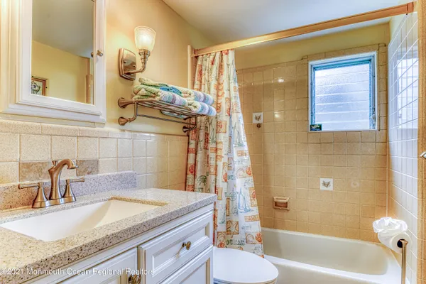a bathroom with a sink a toilet and shower curtain