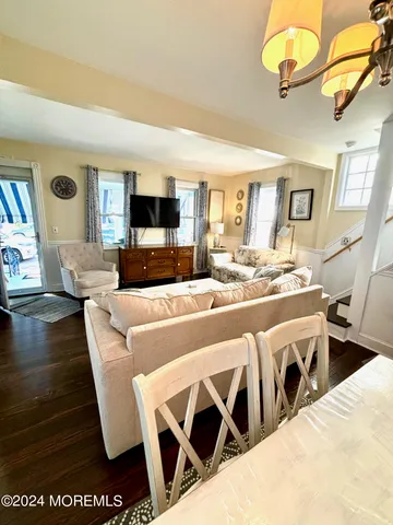 a living room with furniture a flat screen tv and kitchen view