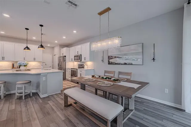 a kitchen with a table chairs refrigerator and microwave