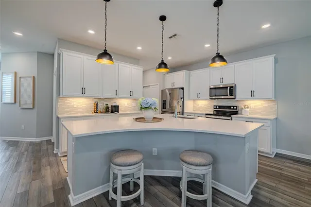 a kitchen with kitchen island a stove a table and chairs