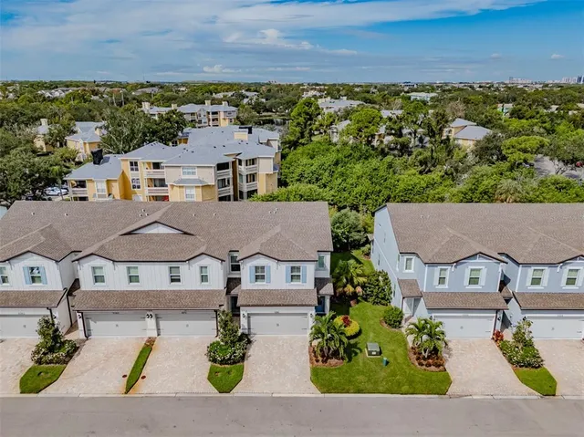 an aerial view of multiple houses with a yard