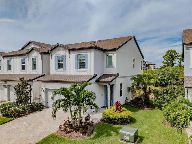a front view of a house with a yard and a garden