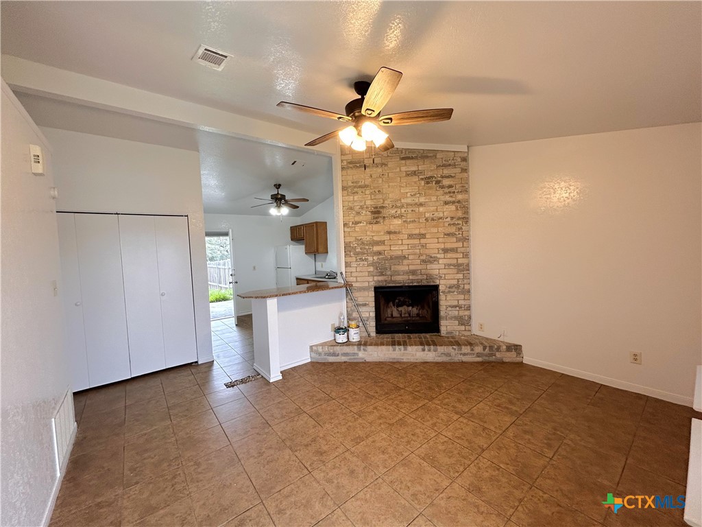 10411 Chaparral Road Killeen, TX 76548 - Photo 2 of 13 a view of a kitchen with a fireplace and a ceiling fan