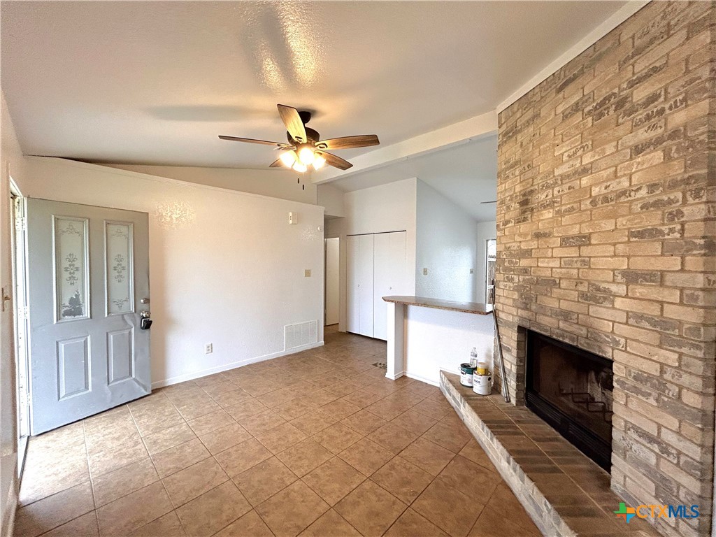 10411 Chaparral Road Killeen, TX 76548 - Photo 3 of 13 a view of a livingroom with a fireplace a ceiling fan and wooden floor