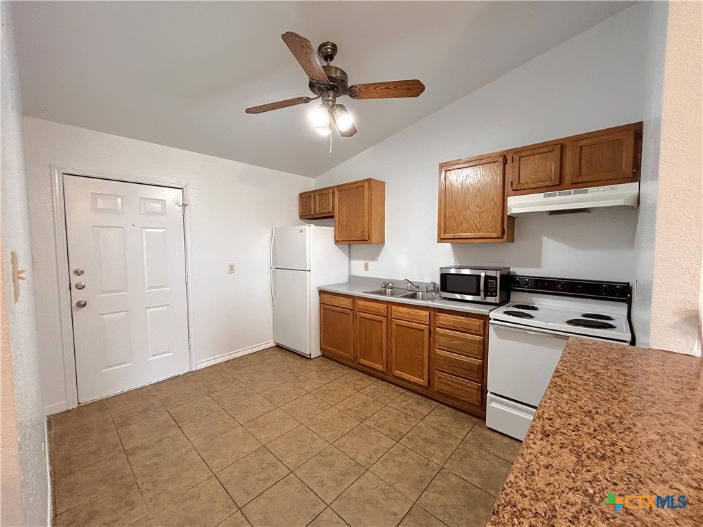 10411 Chaparral Road Killeen, TX 76548 - Photo 4 of 13 a kitchen with a stove a sink and a refrigerator