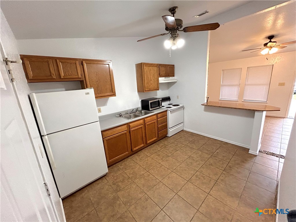 10411 Chaparral Road Killeen, TX 76548 - Photo 5 of 13 a kitchen with stainless steel appliances a refrigerator sink and microwave