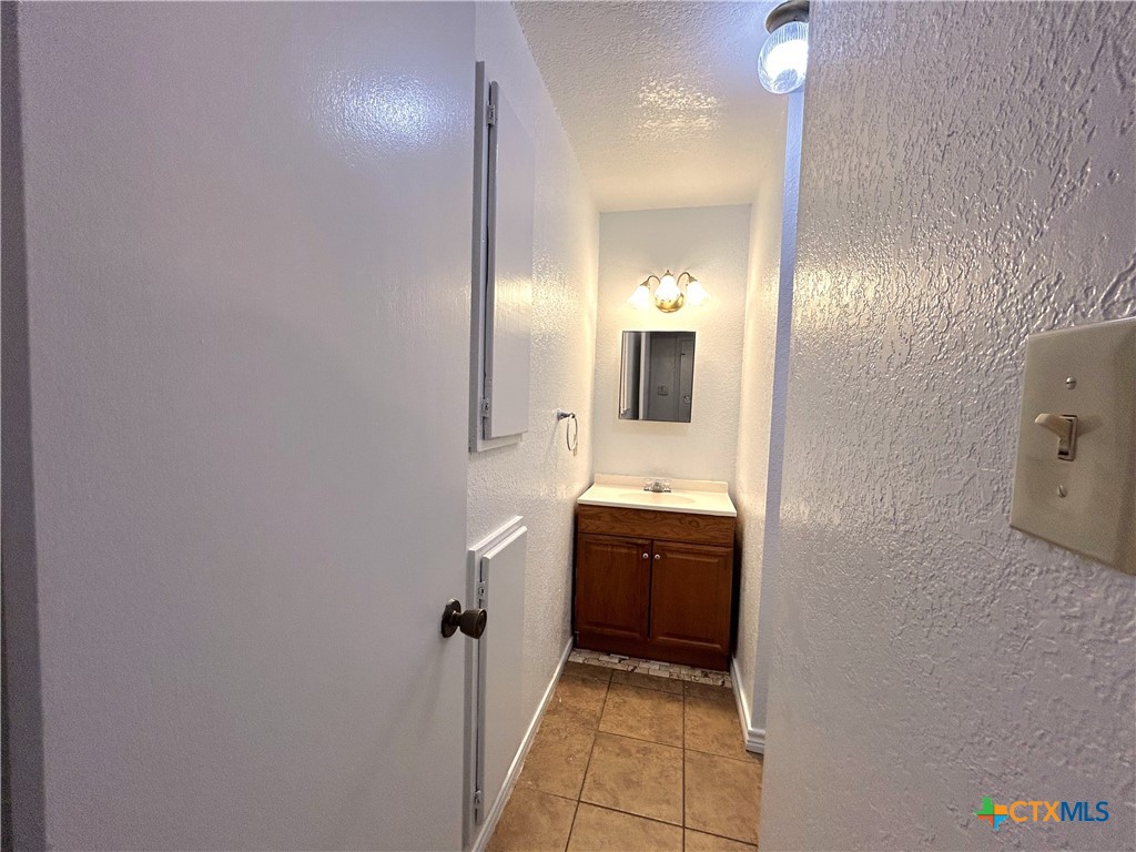 10411 Chaparral Road Killeen, TX 76548 - Photo 7 of 13 a bathroom with a granite countertop sink mirror and toilet