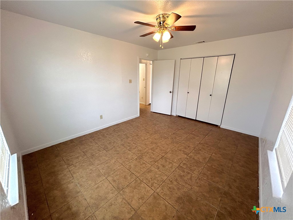 10411 Chaparral Road Killeen, TX 76548 - Photo 9 of 13 an empty room with windows and fan