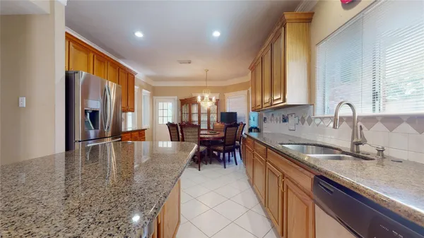 a kitchen with granite countertop a sink a counter top space and stainless steel appliances