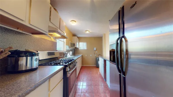 a kitchen with stainless steel appliances granite countertop a refrigerator and a stove top oven