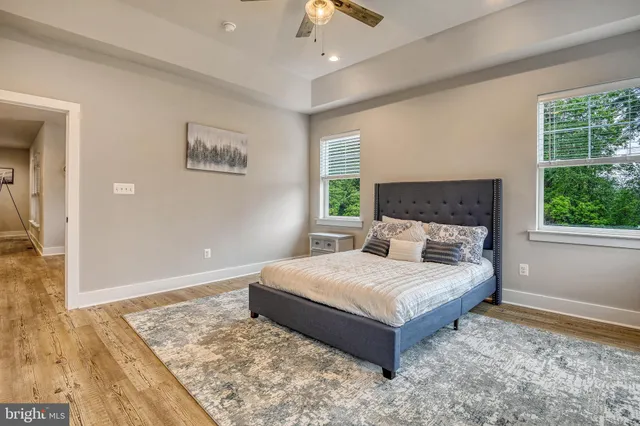 a bedroom with a large bed and a chandelier fan