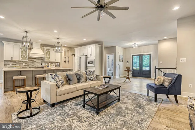 a living room with furniture and a view of kitchen