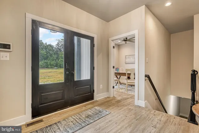 a view of a hallway with wooden floor and windows