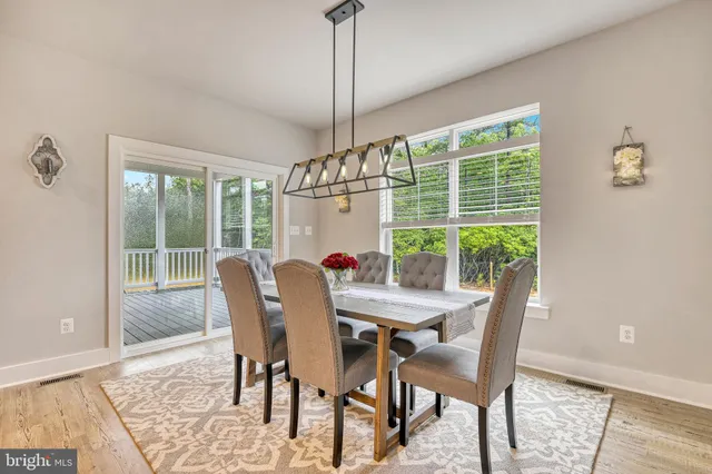 a dining room with furniture a chandelier and wooden floor