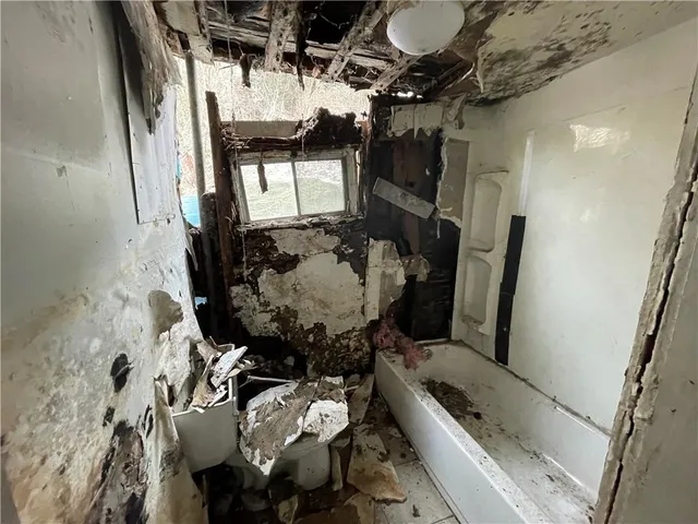 a bathroom with a tub sink and mirror