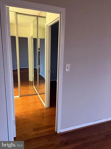 a view of a room with wooden floor and door