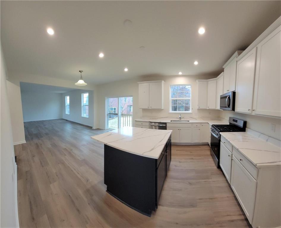236 Wyncrest Drive Butler, PA 16001 - Photo 6 of 23 a kitchen with stainless steel appliances granite countertop a stove top oven a sink dishwasher and a refrigerator with wooden floor