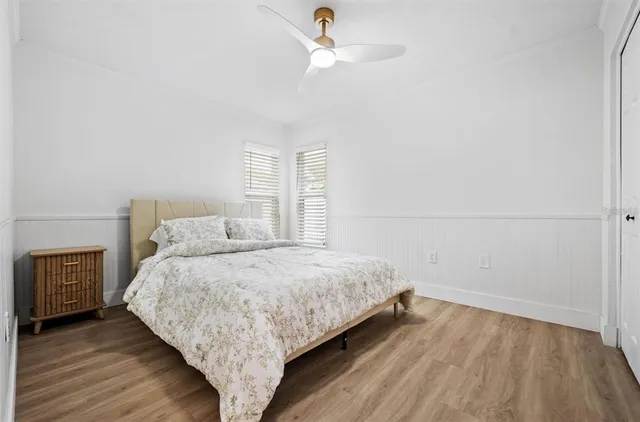 a bedroom with a bed and wooden floor