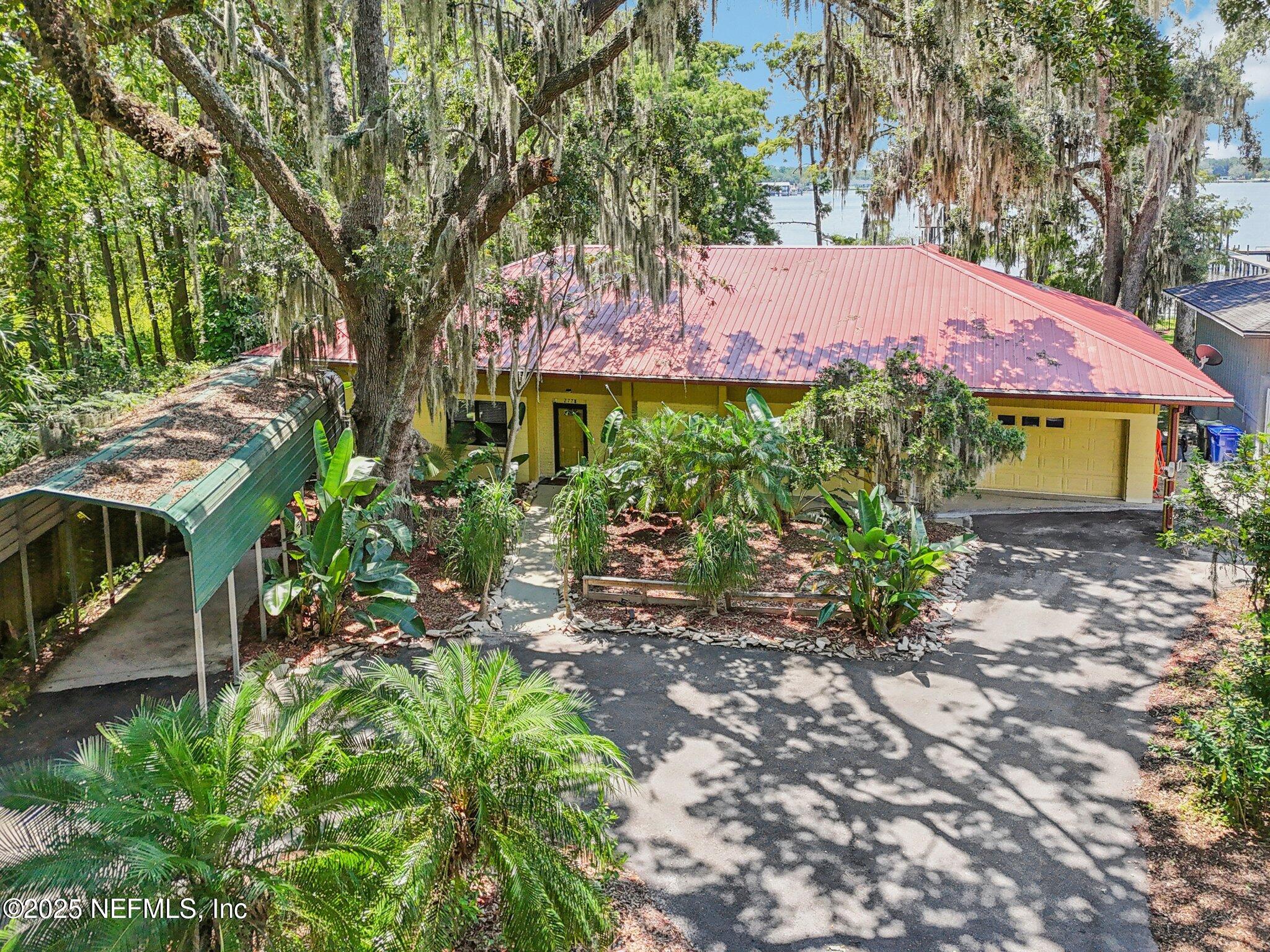2778 Holly Point Road West Orange Park, FL 32073 - Photo 19 of 68 a front view of a house with a yard and potted plants