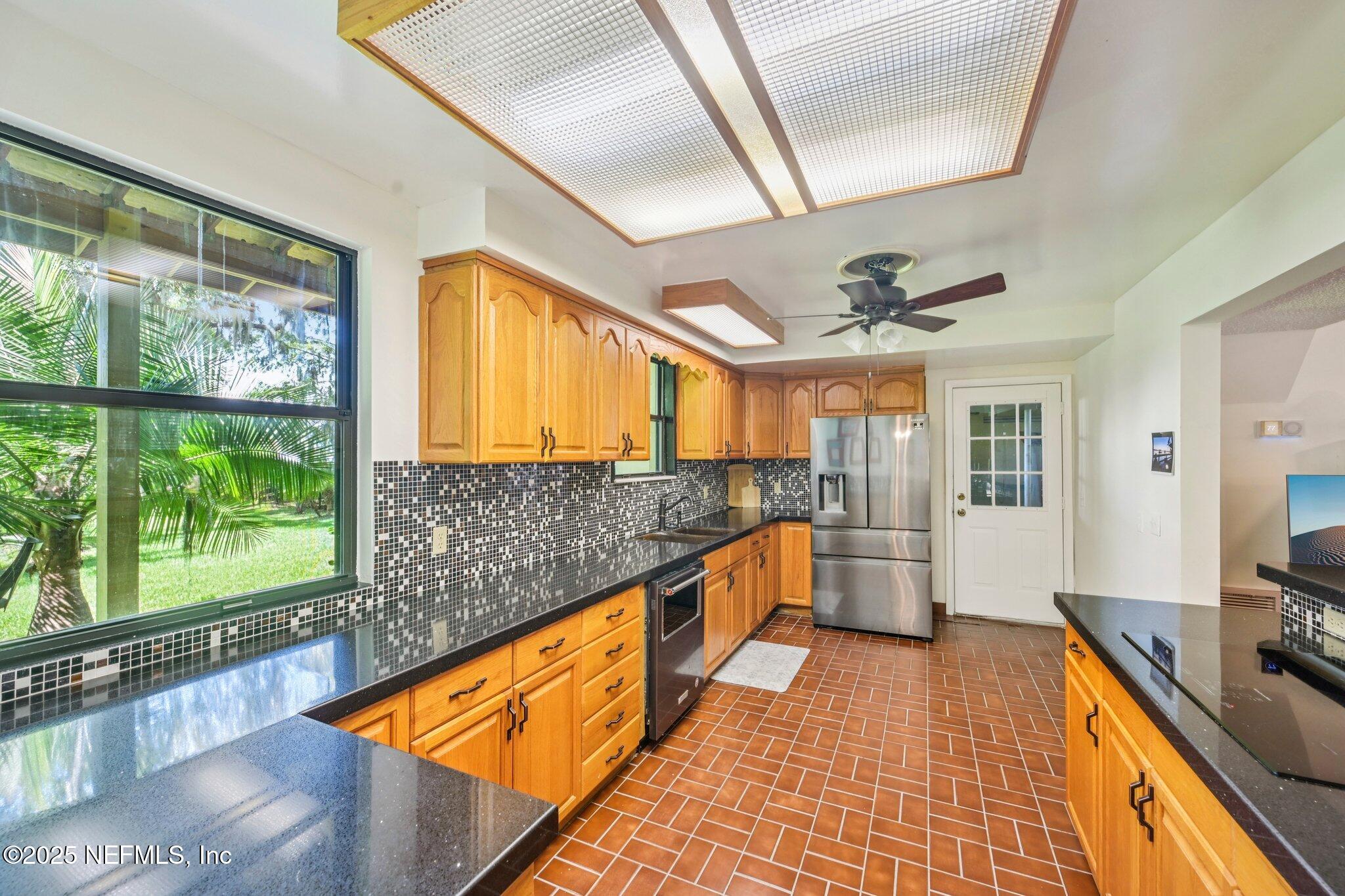 2778 Holly Point Road West Orange Park, FL 32073 - Photo 35 of 68 a large kitchen with stainless steel appliances granite countertop a sink and wooden cabinets