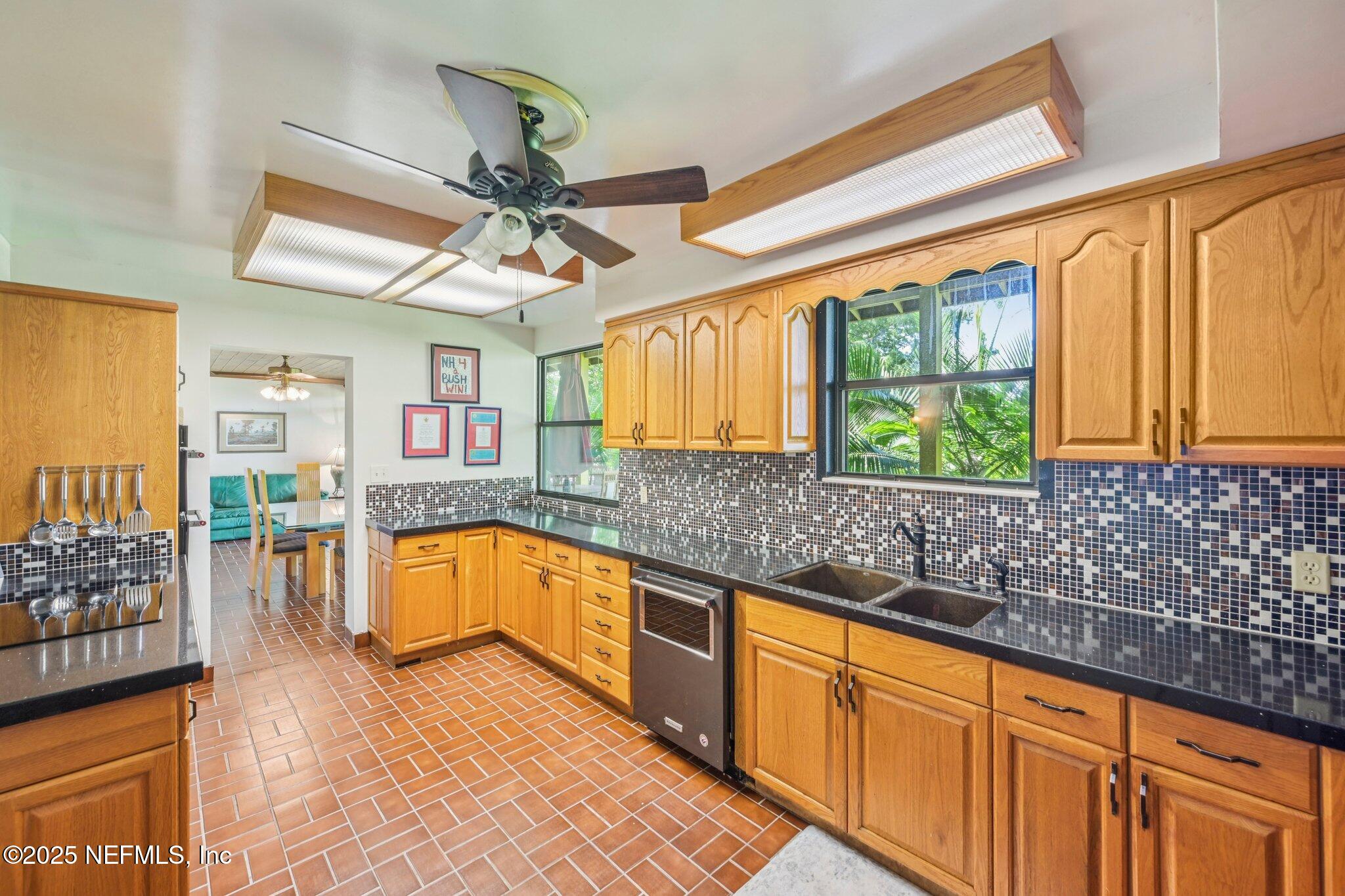 2778 Holly Point Road West Orange Park, FL 32073 - Photo 36 of 68 a kitchen with stainless steel appliances granite countertop a sink cabinets and window