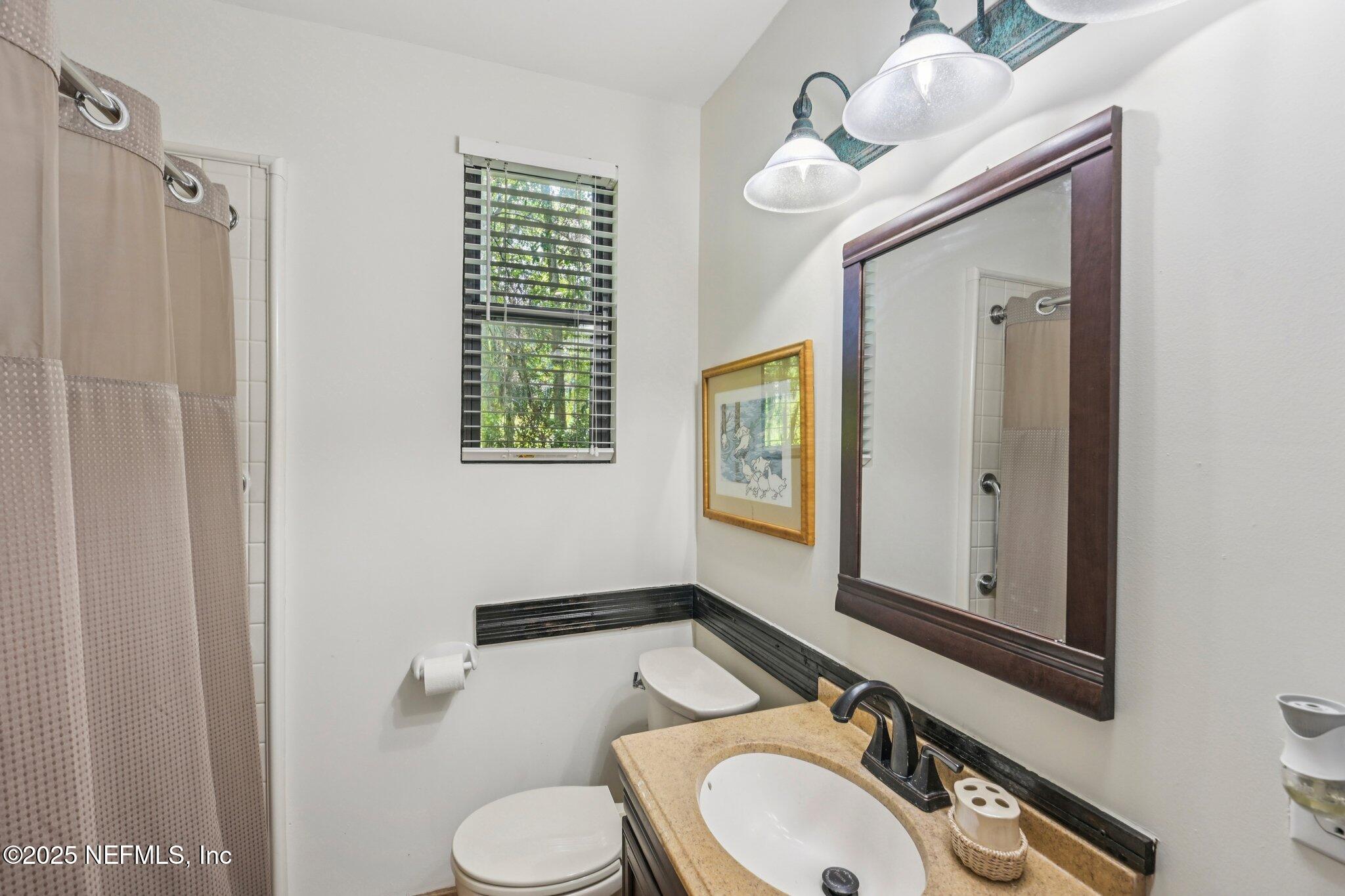 2778 Holly Point Road West Orange Park, FL 32073 - Photo 42 of 68 a bathroom with a sink a toilet and mirror
