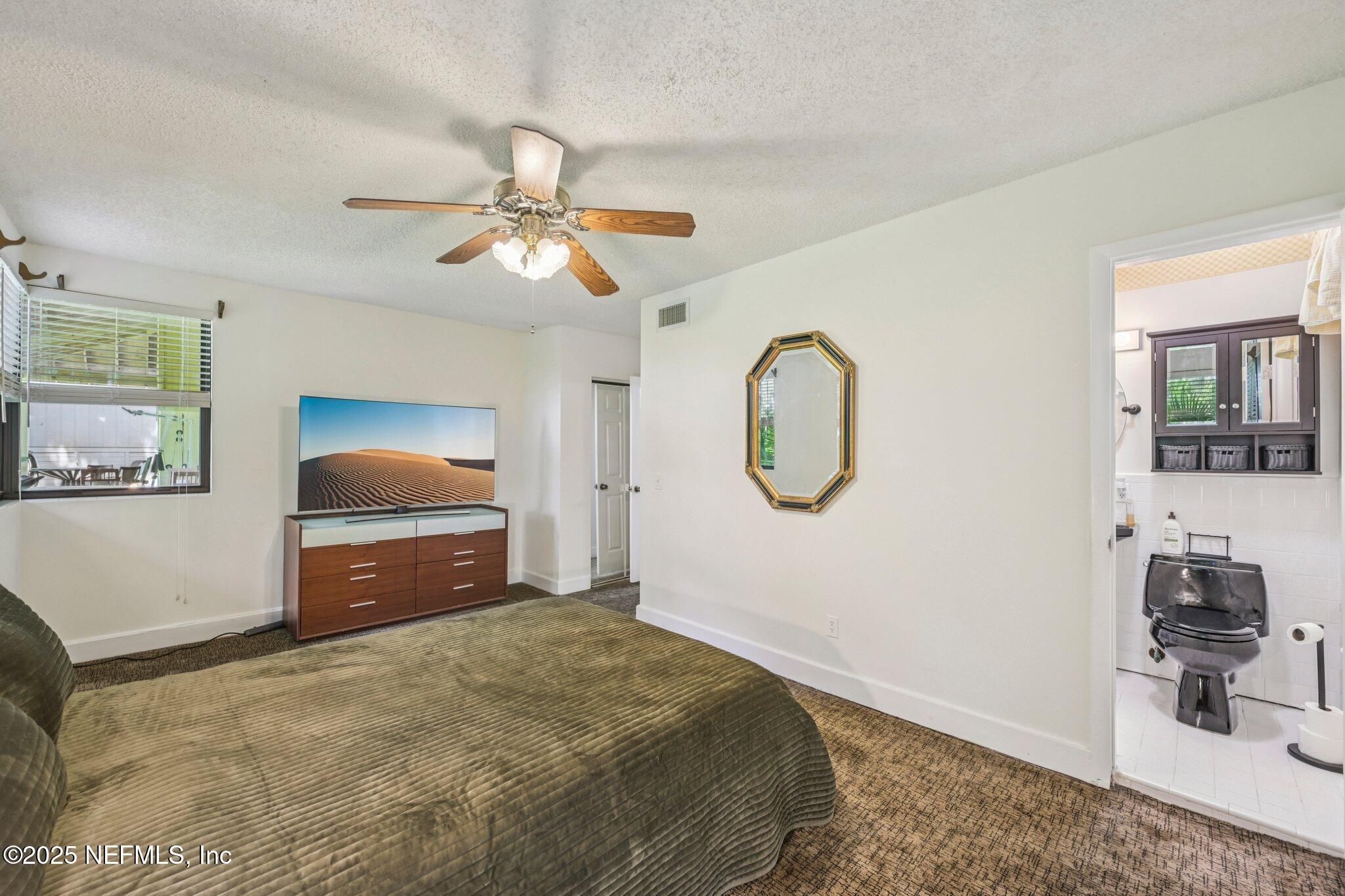 2778 Holly Point Road West Orange Park, FL 32073 - Photo 45 of 68 a bedroom with bed and a chandelier