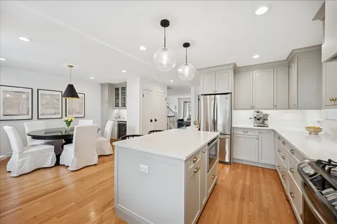 a kitchen with a sink appliances and wooden floor