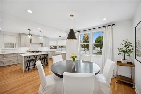 a dining room with furniture potted plants and wooden floor