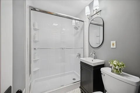 a bathroom with a sink a toilet and shower