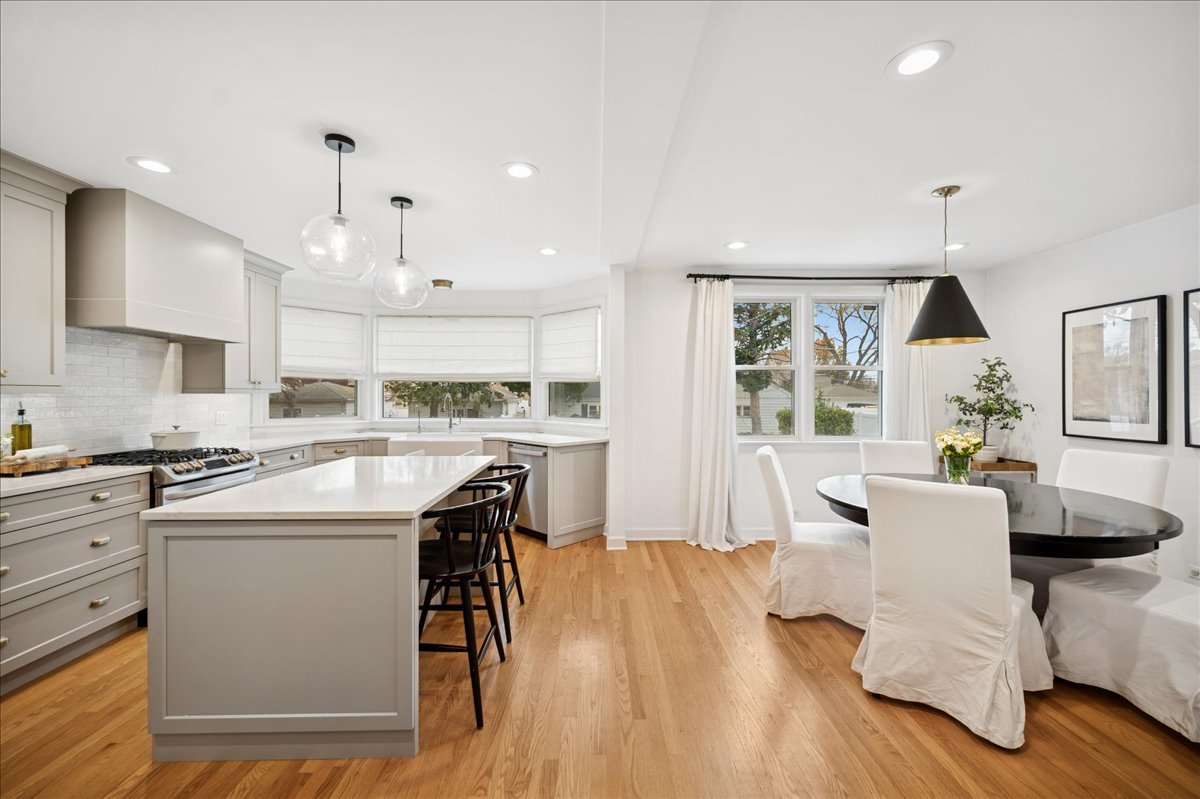 821 Lathrop Avenue Forest Park, IL 60130 - Photo 6 of 38 a kitchen with stainless steel appliances granite countertop a stove top oven a sink dishwasher a dining table and chairs with wooden floor