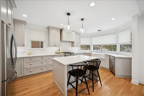 a kitchen with a table chairs refrigerator and cabinets