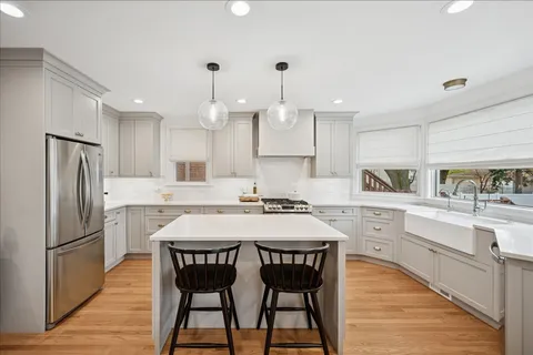 a kitchen with kitchen island granite countertop a sink a center island and stainless steel appliances
