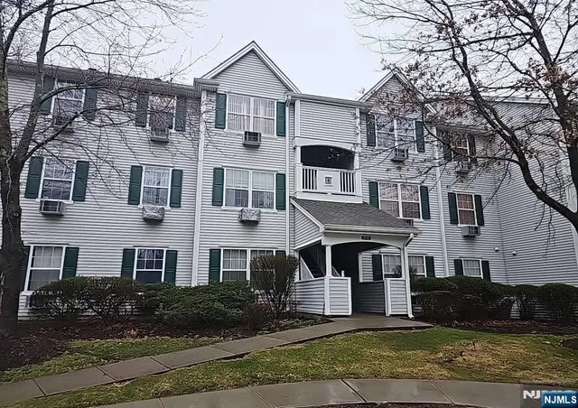 a front view of a house with yard and parking