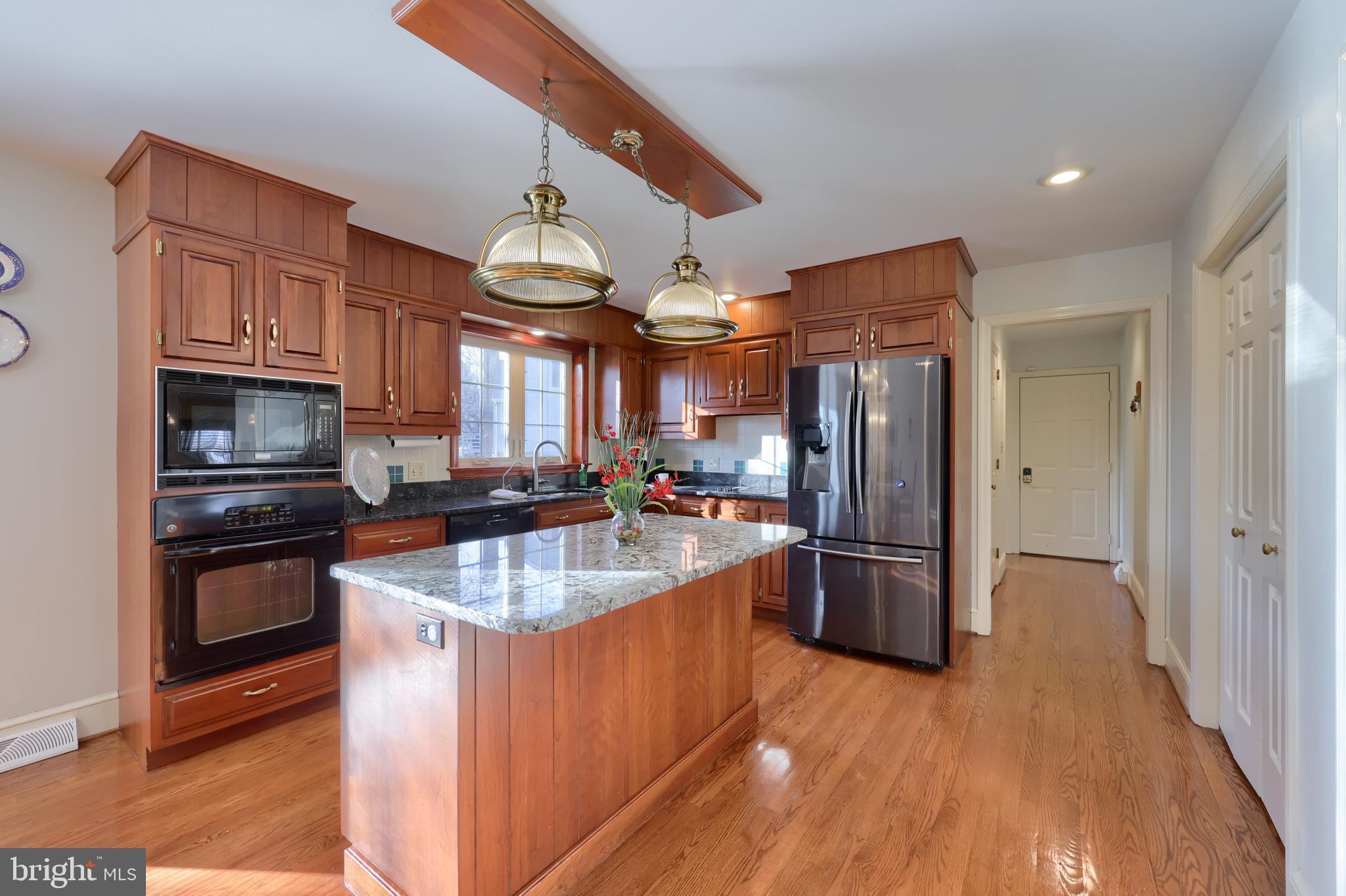 128 Hammersmith Lane Lititz, PA 17543 - Photo 29 of 65 a kitchen with stainless steel appliances granite countertop a refrigerator a sink dishwasher a oven and a dining table with wooden floor