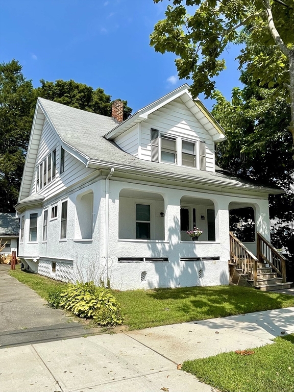 a front view of a house with a yard and outdoor seating