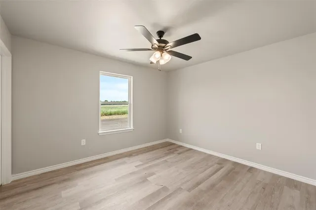 an empty room with a window and a fan